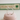 Silver cat ear ring on a pink cushion with a blurred green box in the background