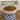 White bowl with cat food on a checkered stand, Feline Fancy sign in the background