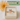 Rose gold ring with cat design in a box with a yellow flower and green box in the background