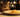 An elegant cat sniffing a plate of pasta 