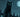 A sleek black cat with glowing green eyes perched on a fence