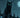 A sleek black cat with glowing green eyes perched on a fence