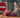 a cat sitting near a bunch of grapes with a warning sign