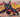 urban graffiti-style artwork of a cartoon warrior cat posed mid-leap with claws out, surrounded by spray-paint textures, layered stencils, and scratch marks on a cracked wall backdrop.