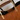 Brown handbag with gold handles and clasp on a white background