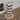 Wooden scratching post with striped design on a wooden floor.