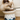 Cat eating from a ceramic bowl with blue mountain design on a wooden floor.