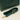 Green crocodile-patterned handbag with matching strap on a light beige background