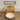 Wooden cat litter box with a white bowl on a wooden floor, branded 'Feline Fancy'.