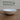 White ceramic bowl on a wooden surface with 'Feline Fancy' sign in the background