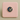 Decorative button with a cat design on a pink cushion