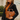 Woman holding a brown leather handbag with a tassel in front of a building with a sign.