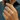 Hand wearing a silver ring with a blurred denim background