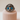 Silver cat-shaped ring with blue eyes on a beige stand