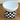 White ceramic bowl with black and white checkered band and 'Lazy Day' text on a wooden surface.