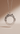 Silver necklace with a round, intricately designed pendant on a beige background