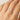 Silver cat-shaped ring on a person's finger against a neutral background