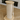 Cat climbing post with wooden top and base on a wooden floor.