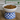 White bowl with cat food on a wooden surface, featuring 'Lazy Day' branding.