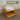 Wooden pet bowl stand with a white bowl on a wooden floor, branded 'Feline Fancy'.