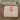 Pink wallet with cat patterns on a wooden surface, branded 'Feline Fancy'.