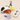 A small robot-shaped cat toy with orange wheels, a black dome, and a bright yellow-green dangling toy attached by a gray loop, shown with a white remote control and a pastel feather tug toy on a light beige background.