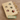 Wooden toy with holes containing small cat toys, branded 'Feline Fancy', on a brown background.