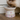 Cat eating from a pink ceramic bowl with cat illustrations on a wooden floor.