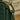 Close-up of a green leather handbag with a gold zipper and handle.