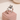 Silver cat-shaped ring on a pink cushion against a beige background