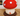 Mushroom-shaped decorative item with red cap and white spots on a wooden floor.