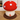 Mushroom-shaped decorative item with red cap and white spots on a wooden floor.